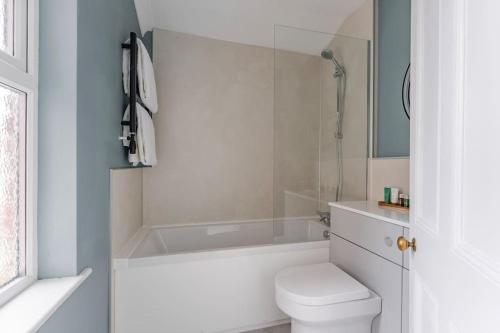 a bathroom with a tub and a toilet and a sink at Family & pet Friendly, Stylish & Spacious Beach House in Gorleston-on-Sea
