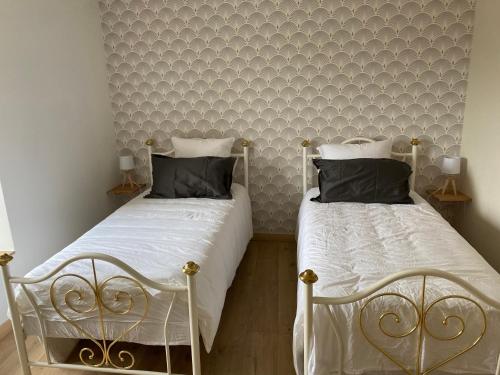 twee bedden naast elkaar in een slaapkamer bij Gîte en plein cœur des vignobles in Paris-lʼHôpital