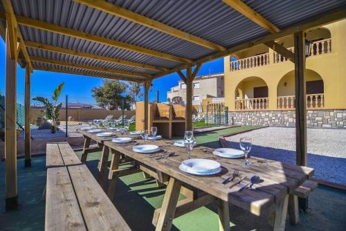 una larga mesa de madera con platos y vasos. en Villa Ambar - PlusHolidays, en Calpe