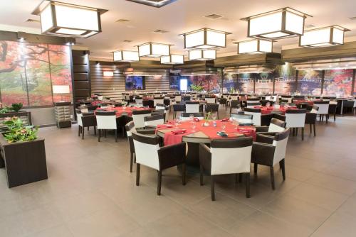 a dining room with tables and chairs and chandeliers at Ramada by Wyndham Princess Paramaribo in Paramaribo