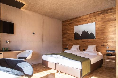 a bedroom with a bed and a desk and a television at Hotel Arlmont 4 Stern Superior in Sankt Anton am Arlberg