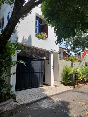 a white house with a black garage door at Colombo 07 Charming Home Stays in Colombo