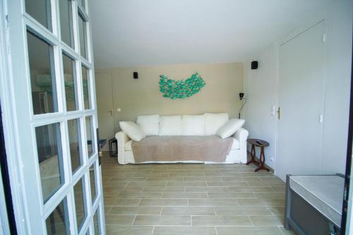 uma sala de estar com um sofá branco num quarto em Pyla sur mer proche plages appartement avec piscine em Pyla-sur-Mer