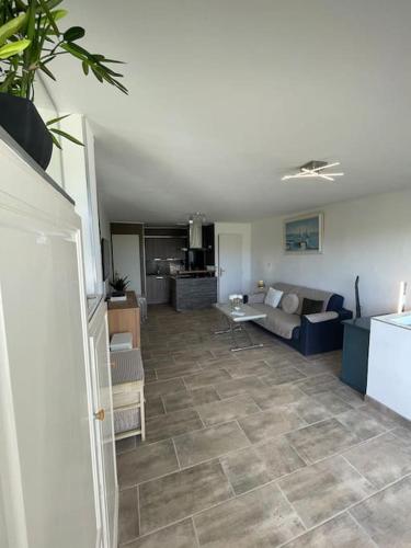 un salon avec un canapé et une cuisine dans l'établissement Appartement duplex Vil’Adonis, au Cap d'Agde