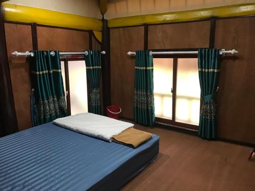 Schlafzimmer mit einem Bett und einem Fenster mit Vorhängen in der Unterkunft Bee Lucky Homestay in Cát Bà