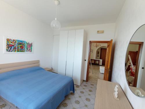 ein Schlafzimmer mit einem blauen Bett und einem Spiegel in der Unterkunft Casa Vacanze MaMare in Bari