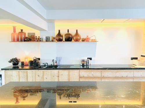 a kitchen with a counter with vases on the wall at stunning luxury duplex downtown Knokke in Knokke-Heist