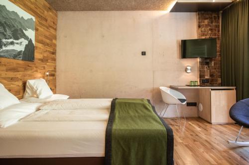 a hotel room with a bed and a television at Hotel Arlmont 4 Stern Superior in Sankt Anton am Arlberg