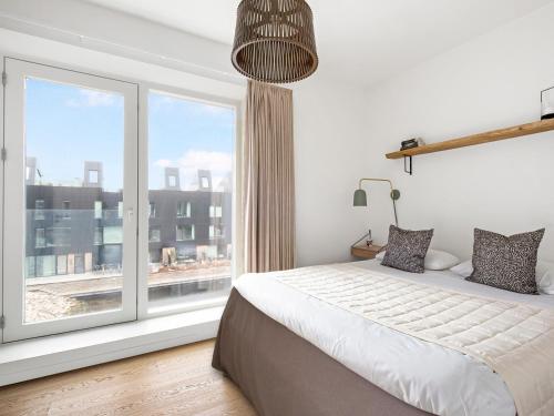 a bedroom with a bed and a large window at Sanders Pier - Fantastic 3-Bedroom Townhouse with Balcony Terrace in Copenhagen