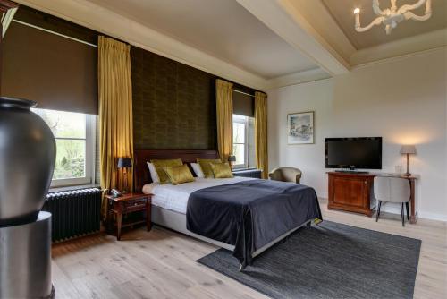 a bedroom with a bed and a flat screen tv at Hof de Draeck Bed & Breakfast in Teuven