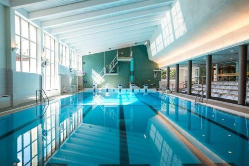 a large swimming pool with blue water in a building at Premium Chalet 4212 Green in Heinola