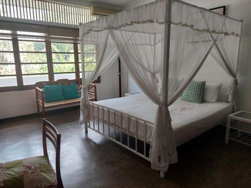 um quarto com uma cama de dossel num quarto com janelas em Colombo 07 Charming Home Stays em Colombo