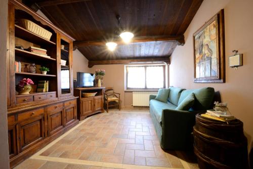 a living room with a blue couch and a television at Agriturismo Le Querce di Assisi in Assisi