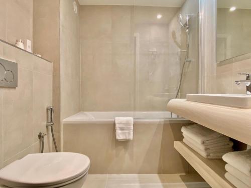 e bagno con servizi igienici, lavandino e doccia. di Hôtel Central Saint Germain a Parigi