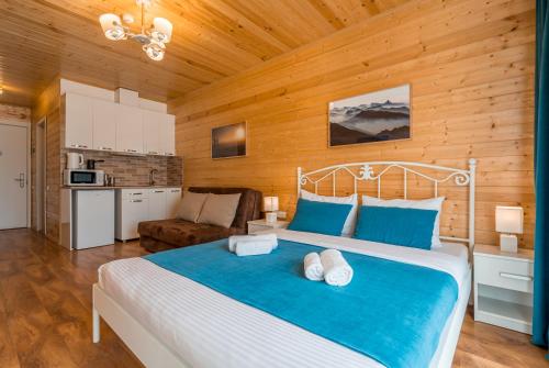 a bedroom with a large bed and a kitchen at New Gudauri Ski4Life in Gudauri