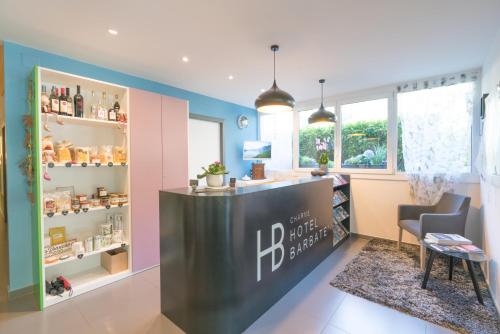a barber shop with a counter and a chair at Charme Hotel Barbatè in Tegna