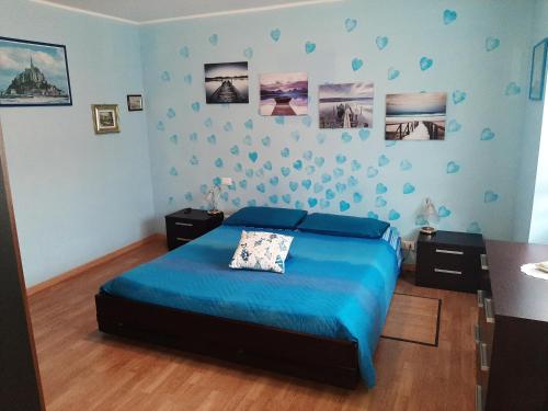 um quarto com uma cama azul e um edredão azul em Appartamento Cascate delle Marmore em Le Marmore