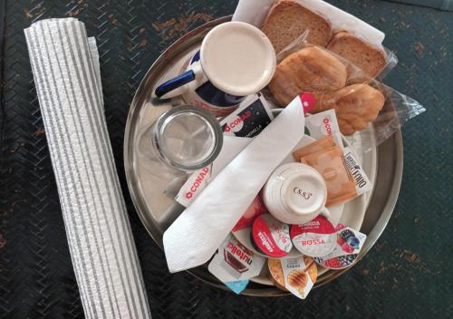 un plato de comida con pan y una taza de café en B&B Le Finestre Su Via Cavour, en Sassari