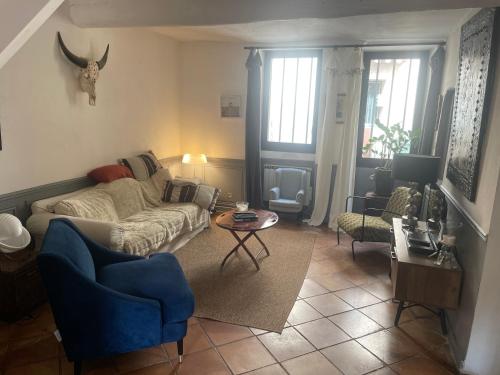 a living room with a couch and a table at la villageoise, chambre troglodyte pitoresque au cœur du village in Rognes