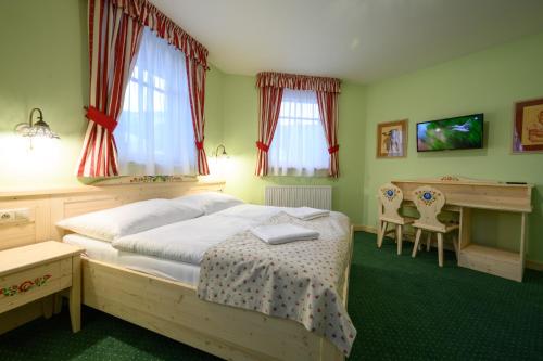 a bedroom with a bed and a desk in it at Hotel Julianin dvor in Habovka