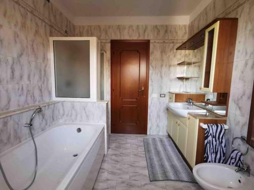 西爾米奧奈的住宿－Villa Grifone，带浴缸和盥洗盆的浴室
