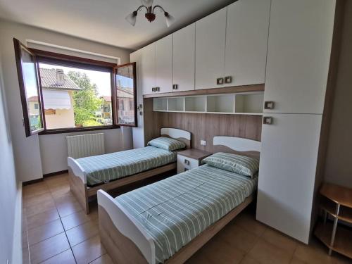 西爾米奧奈的住宿－Villa Grifone，一间卧室设有两张床和窗户。