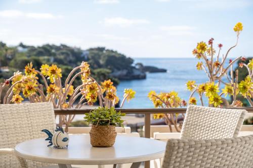 a table with a potted plant on top of a balcony at Apartamento Caballito de Mar in Felanitx