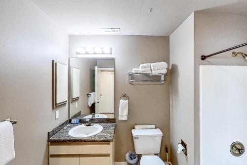 a bathroom with a sink and a toilet and a mirror at Lake Chelan Shores Sleek Stunner 19 to 4 in Chelan