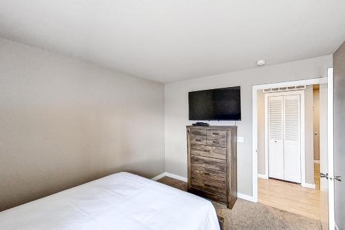 a bedroom with a bed and a flat screen tv at Lake Chelan Shores Sleek Stunner 19 to 4 in Chelan