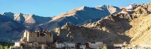 a building in front of a mountain with mountains at Hotel Bergo Residency - Leh in Leh