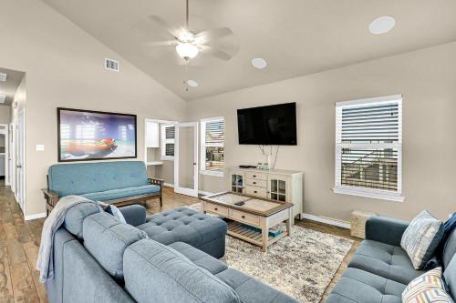 a living room with blue couches and a flat screen tv at The Blue Pelican in Corpus Christi
