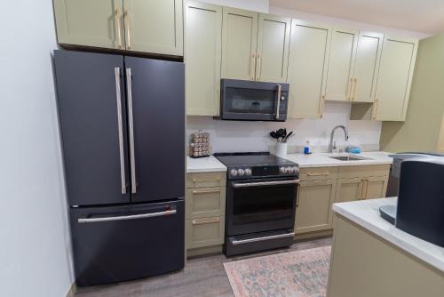 a kitchen with a black refrigerator and a stove at Colony Suites in Palmer