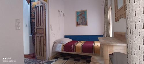 ein Schlafzimmer mit einem Bett und einem Schreibtisch in einem Zimmer in der Unterkunft Vallparadis Pension Familiar" FIRDAUS" in Chefchaouen