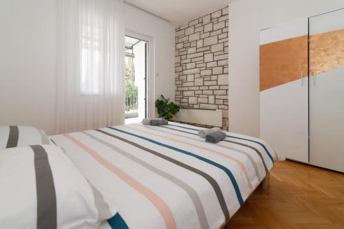 ein Schlafzimmer mit einem großen Bett und einer Ziegelwand in der Unterkunft Apartments Jasna 3 in Novigrad Istria