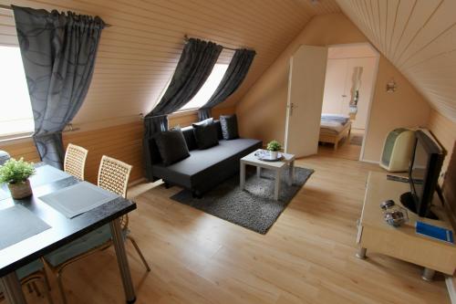 een woonkamer met een bank en een tafel bij Wunderschön zwischen Ortsausgang und Waldesrand gelegene, schöne Apartments in Herzogenrath