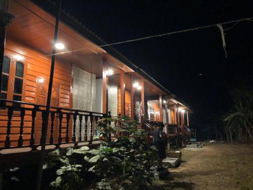 a man standing in front of a house at night at Letana Guesthouse in Ban O