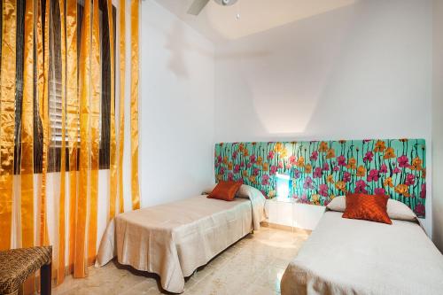 una camera con due letti e una tenda colorata di Profumo di Mare a Custonaci