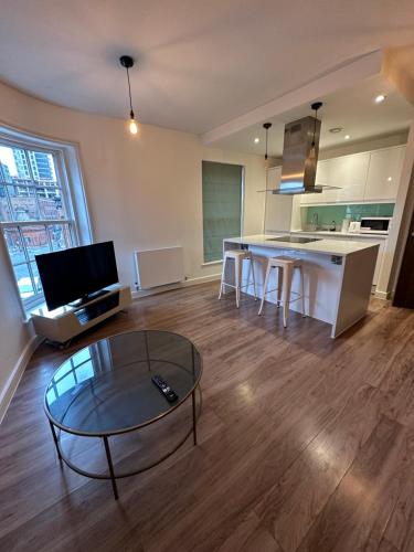 a living room with a table and a kitchen at BigKings Stylish 1Bed Apartment in central Manchester in Manchester