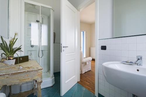 bagno bianco con lavandino e doccia di Villa Ala ad Augusta