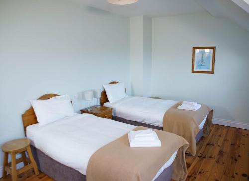 a hotel room with two beds and a stool at Dingle Courtyard Holiday Homes 3 Bed Sleeps 6 in Dingle