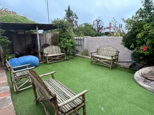 a yard with two chairs and a tent and grass at Cozy Crner Kitehouse in Langebaan