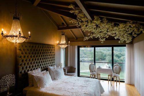a bedroom with a bed and a table and chairs at Quinta do Burgo - Nature Hotel in Amares