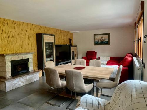 een woonkamer met een houten tafel en een open haard bij Casa Rural en Santa Cruz-Mieres in Bustiello