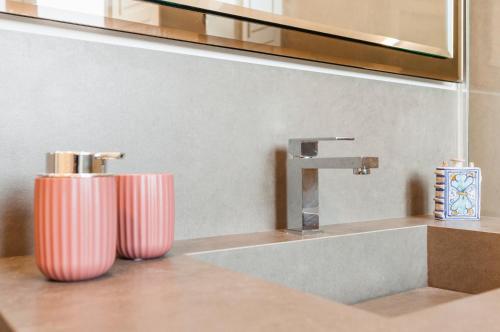 un bagno con due vasi rosa accanto a un lavandino di 2 Soru Ortigia Holiday Home - Attico con terrazza a Siracusa