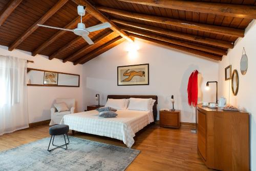 Schlafzimmer mit einem Bett und einem Deckenventilator in der Unterkunft Palmento La Rosa in Pedara