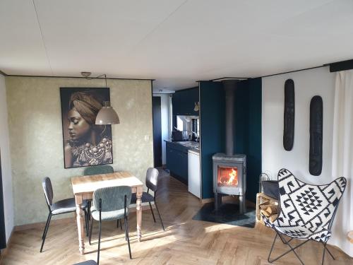 a living room with a table and chairs and a fireplace at Vintage chalet Fereale II in Grou