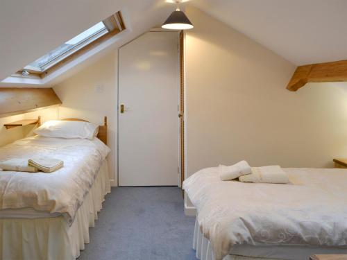 a attic bedroom with two beds and a skylight at Quiet Ways in Portinscale