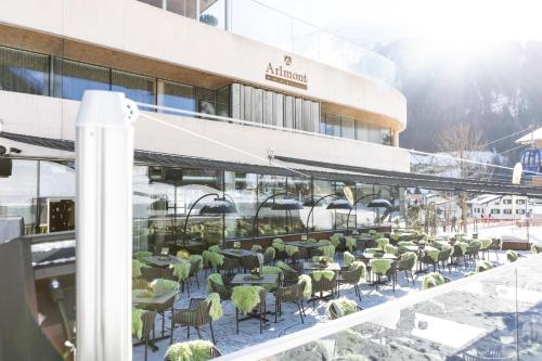 a row of tables and chairs outside of a building at Hotel Arlmont 4 Stern Superior in Sankt Anton am Arlberg