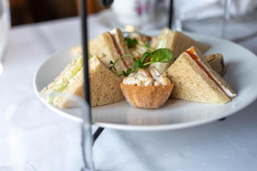 a plate of sandwiches and nuts on a table at GamlaVærket Gjæstgiveri og Tracteringssted in Sandnes