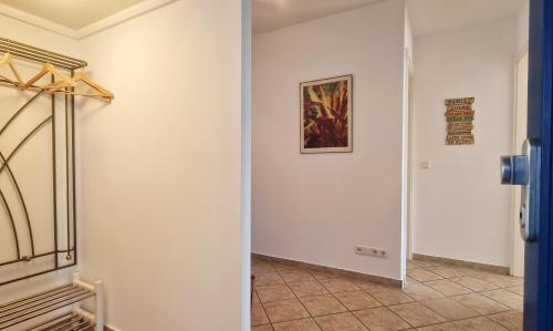 a hallway with white walls and a painting on the wall at Ferienwohnung Golfblick in Wittenbeck